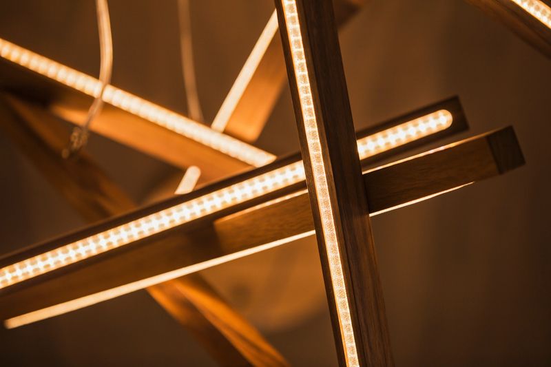 Led light lamp illuminated. Installation of a geometric hanging wooden chandelier