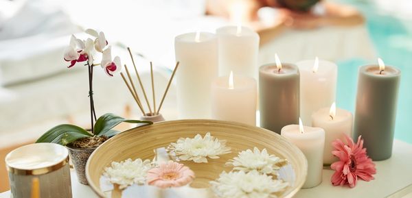 A serene spa setup with floating flowers and lit candles.