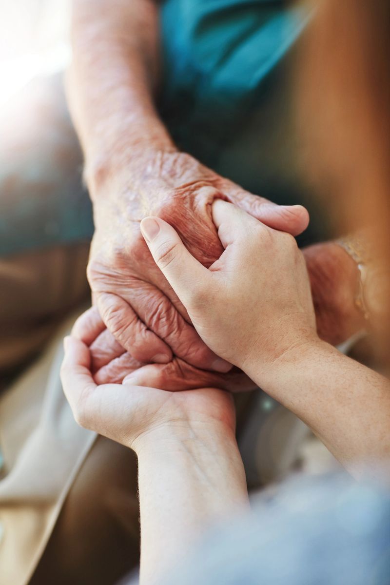 Closeup shot of an unrecognizable woman holding a senior man's hands in comfort