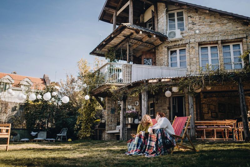 Lovely and beautiful young couple enjoying their time together in a front yard of their house.