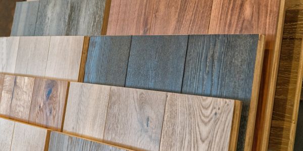 Various wood flooring samples arranged in overlapping rows.