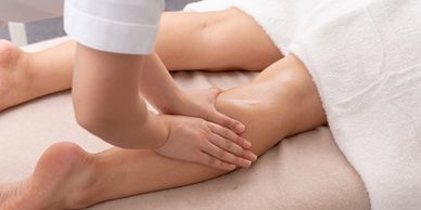 A person receiving a leg massage in a spa setting.