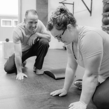 A trainer encouraging a woman during a workout session.