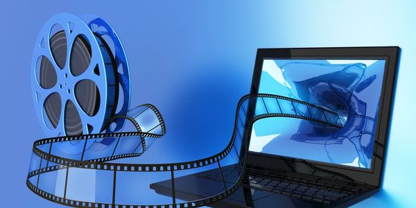 Film reel and laptop interconnected by filmstrip.