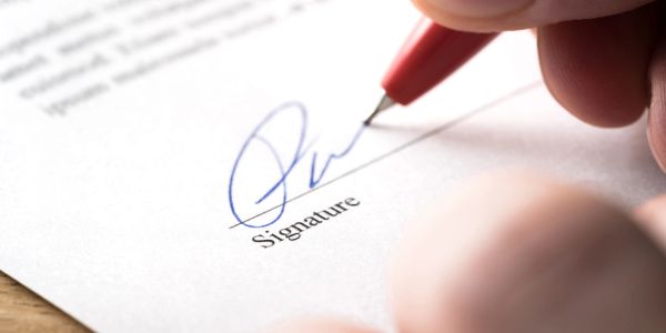 Close-up of a pen signing a document.