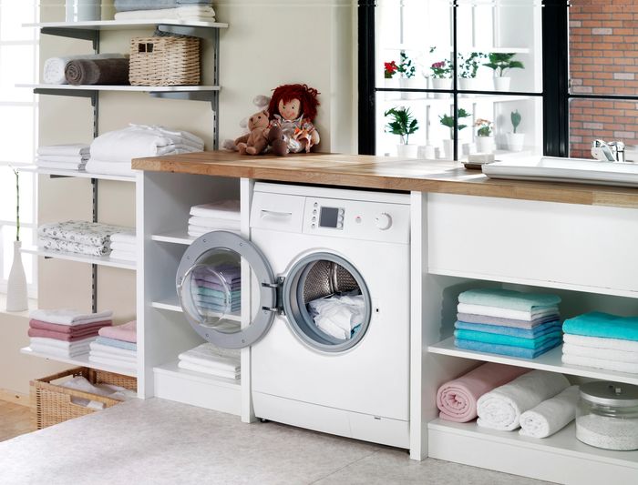 Modern laundry room with washing machine and neatly folded towels.