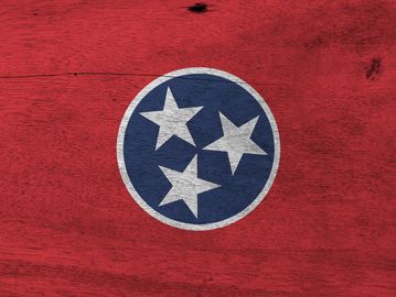The Tennessee state flag symbol with three stars on a red background.