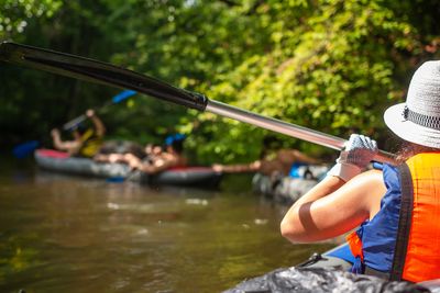 Person kayaking on a calm river surrounded by greenery.