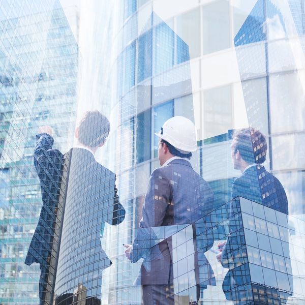 Construction managers & engineer reviewing development plans for high-rise building in downtown Hou