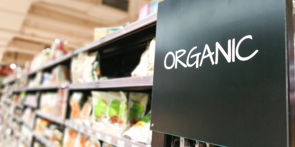 Grocery store aisle labeled 'Organic' with shelves of packaged goods.