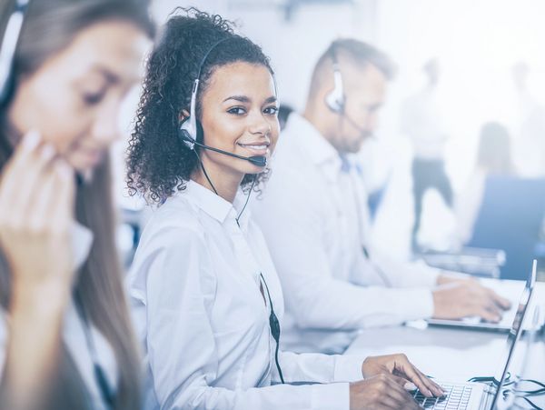 Customer service team wearing headsets and working on laptops.
