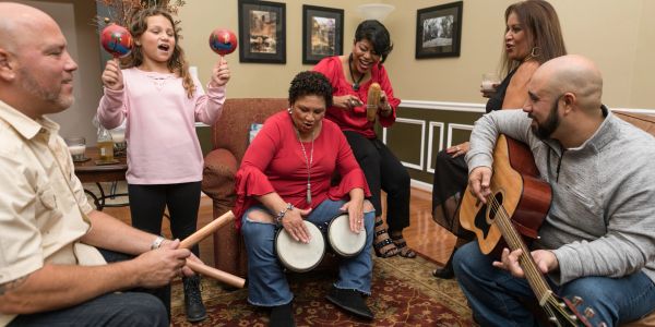 Family playing musical instruments together at home.
