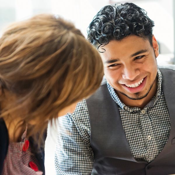 Two people smiling and engaging in conversation.