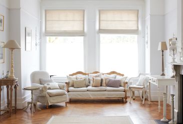 Bright living room with classic white furniture and wooden accents.