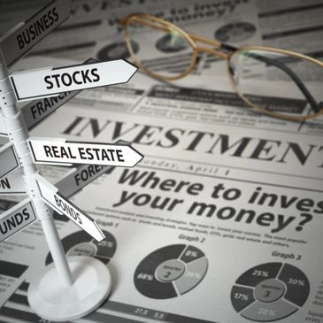 A signpost with investment options over an investment newspaper and glasses.