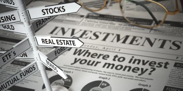 Signpost with investment options over a newspaper about investing money.