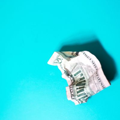 Crumpled five-dollar bill on a bright blue background.