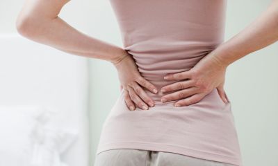 Person holding their lower back in pain.