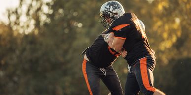 Fullback wearing a neck roll running with football.