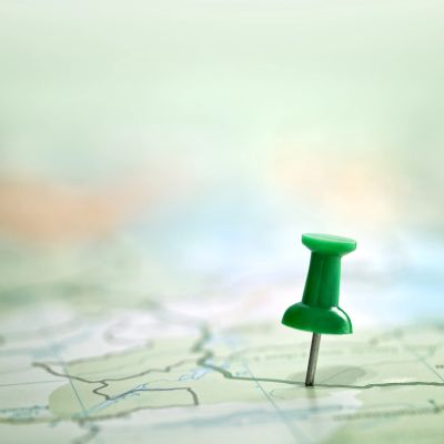Green pushpin on a map.