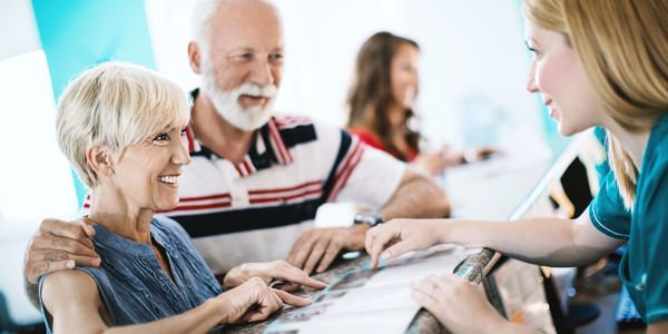 Senior couple consulting with a receptionist at a medical office.