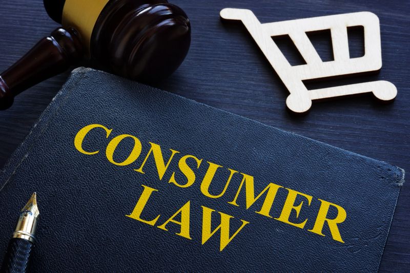 Consumer law, gavel and shopping cart on a desk.