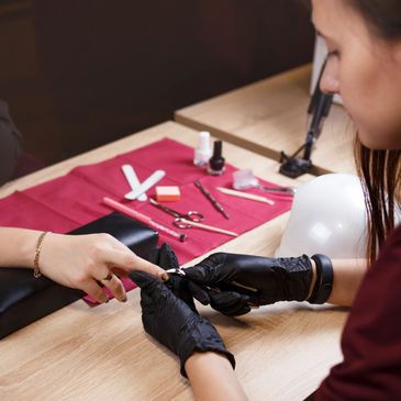 A professional manicure in progress with tools on the table.