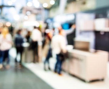 Blurred crowd walking in an indoor space.