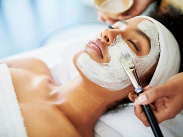 Woman enjoying a relaxing facial mask treatment at a spa.