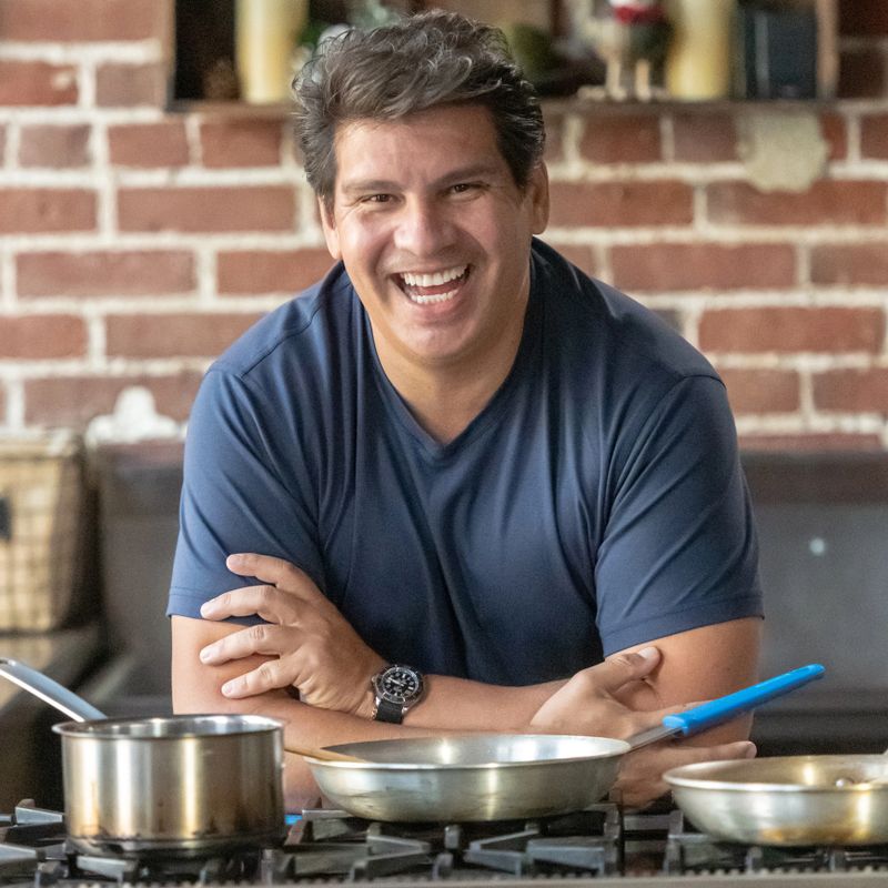 Mature hispanic man posing smiling looking at the camera at his business kitchen