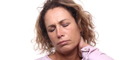 Woman with closed eyes holding her neck in discomfort.