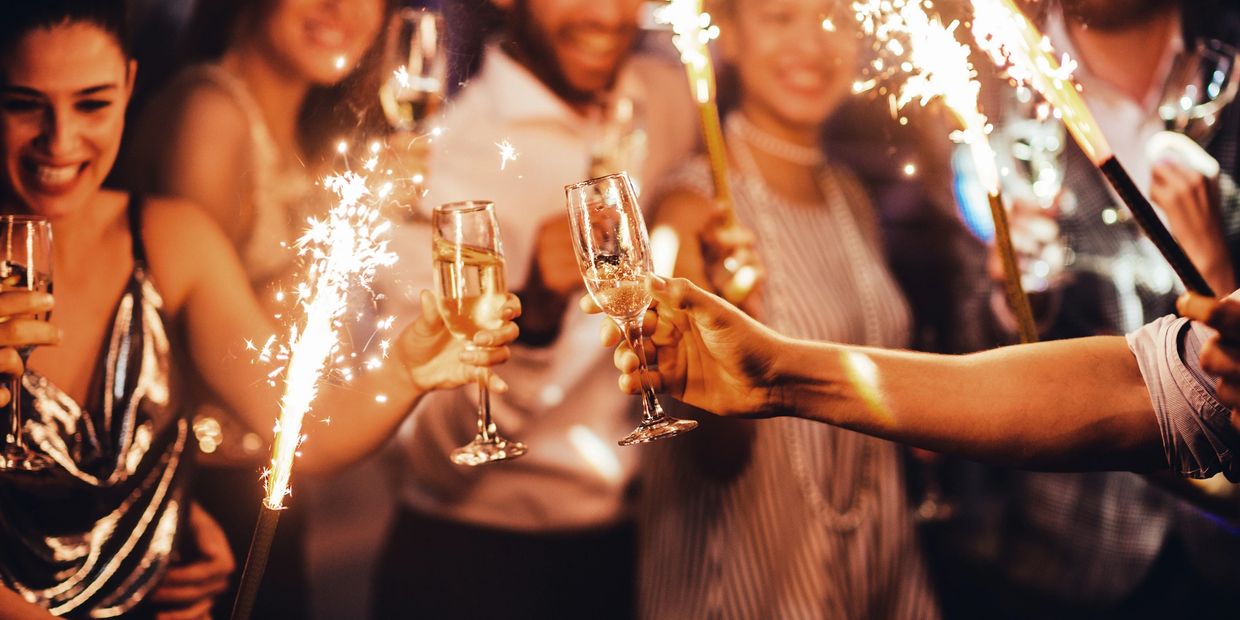 Friends celebrating with champagne and sparklers in a lively party.