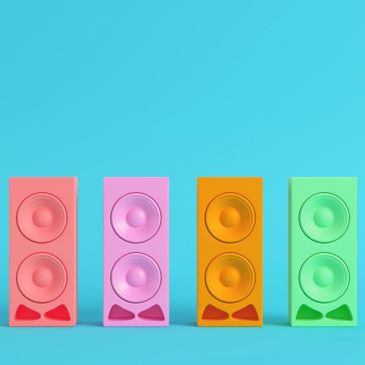 Colorful modern speakers in a row against a blue background.