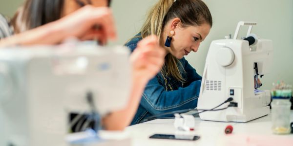 Woman focused on using a sewing machine.