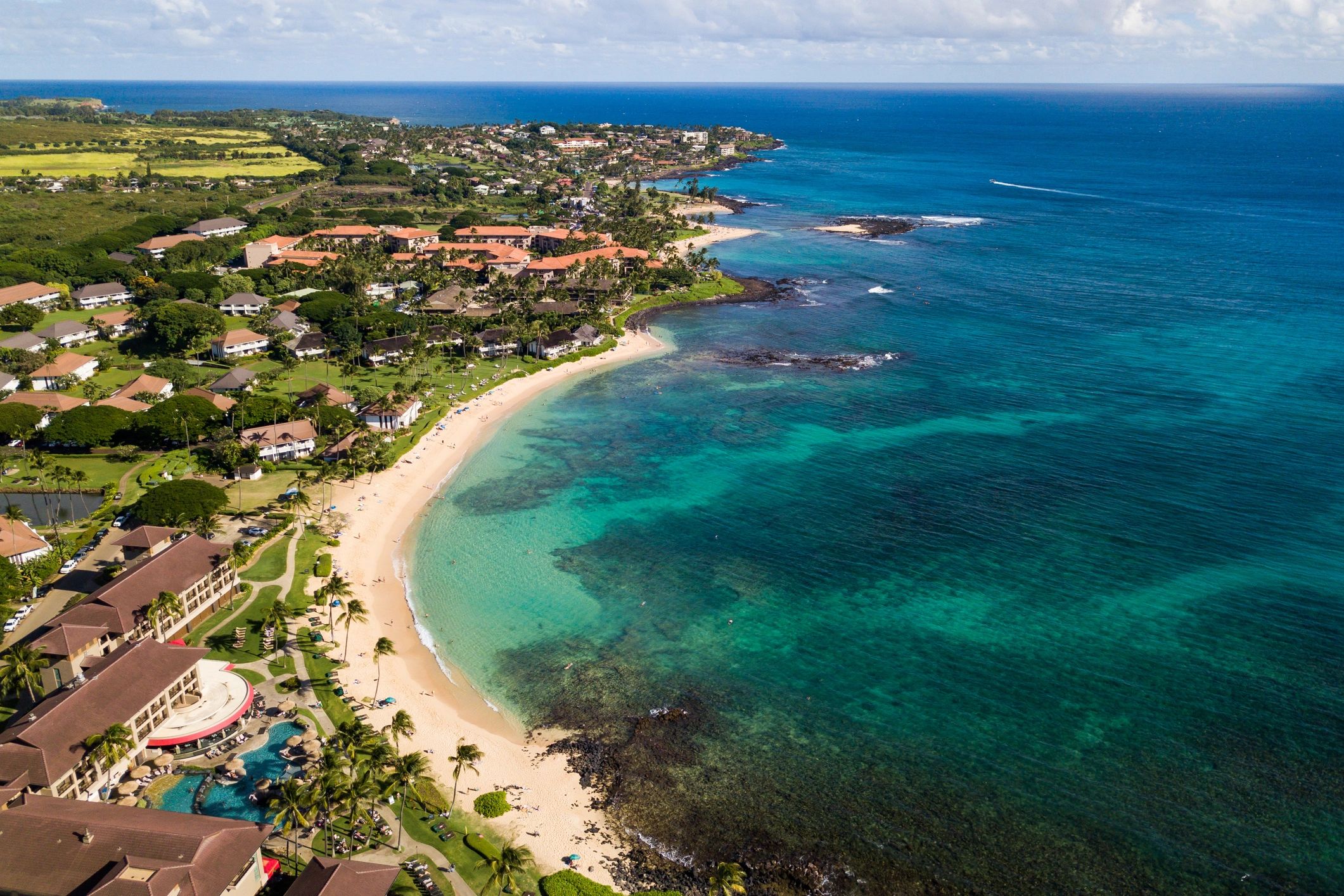 Aerial overview of Poipu Beach and the beachfront grounds of the Sheraton Kauai Resort.