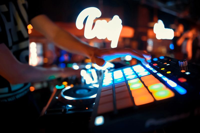 Dj mixes the track in the nightclub at party