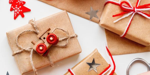 Brown paper wrapped gifts with red and white decorations.