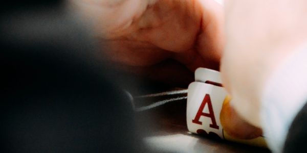Close-up of hands holding playing cards with an Ace visible.