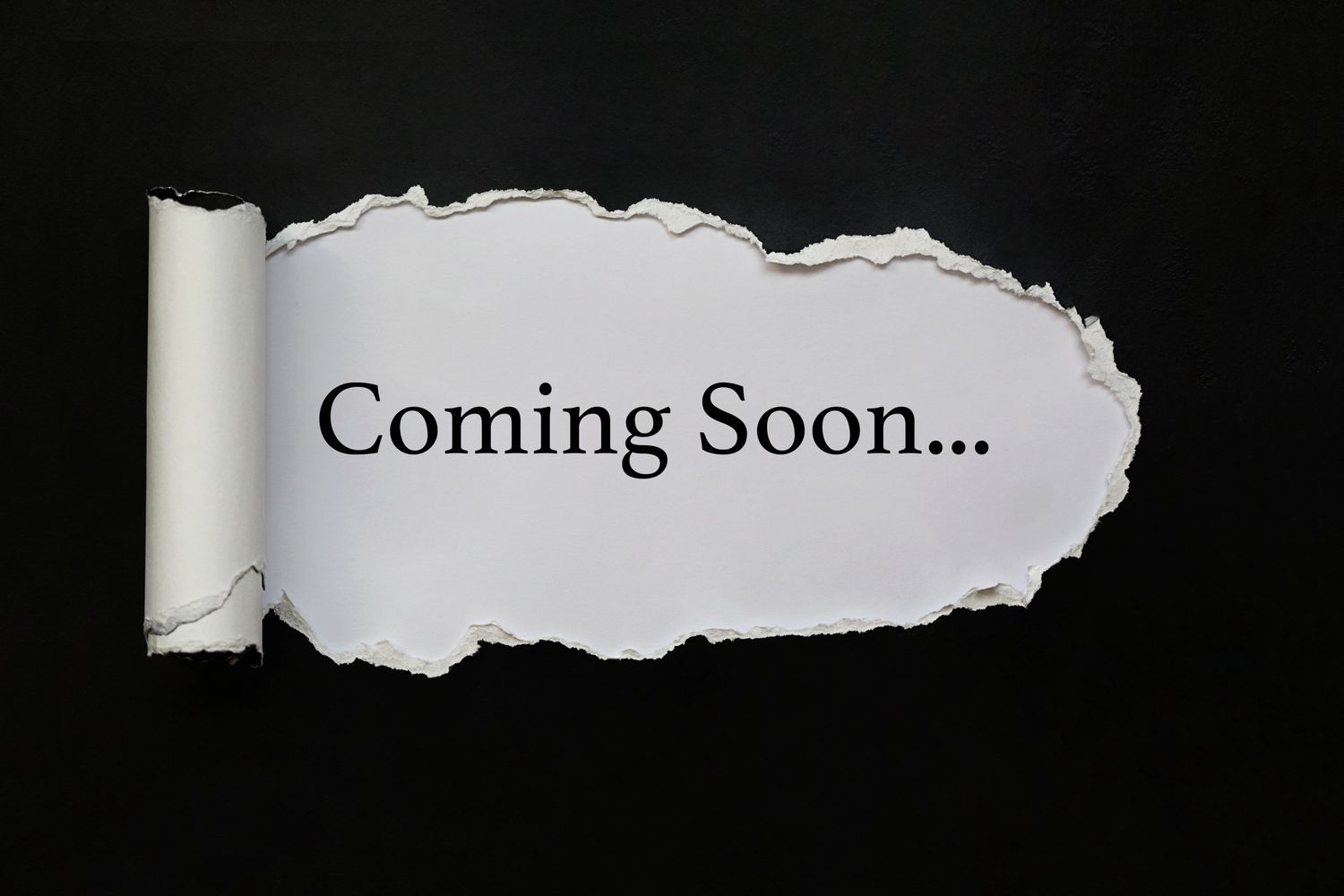 Torn paper revealing the words 'Coming Soon...' on a black background.