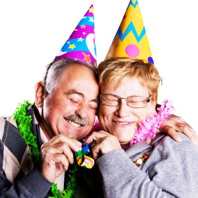 Elderly couple celebrating with party hats and joyful expressions.