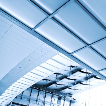 Modern blue-toned ceiling with glass and metal structure.