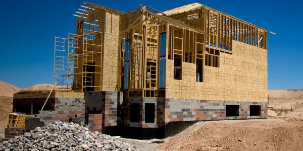 A wooden house frame under construction on a clear day.