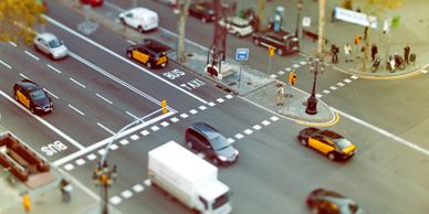 A busy urban intersection with cars and buses in motion.