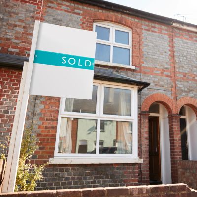 Brick house with sold sign in front.