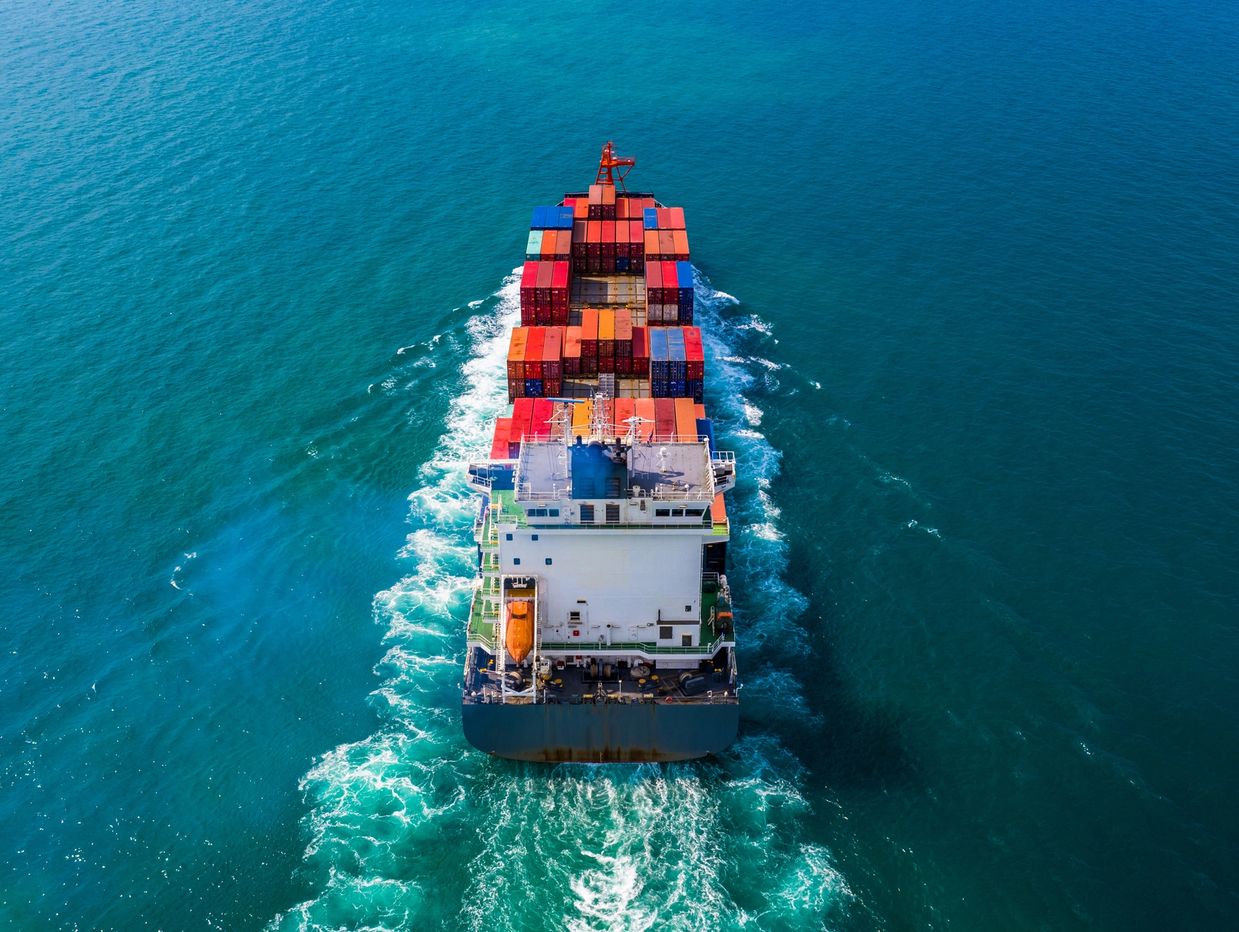 Cargo ship sailing on the ocean with colorful containers.