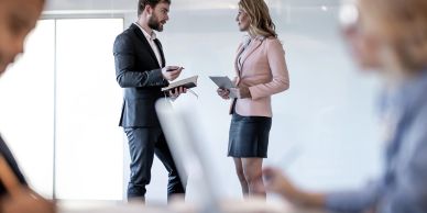 Two professionals discussing work in an office.