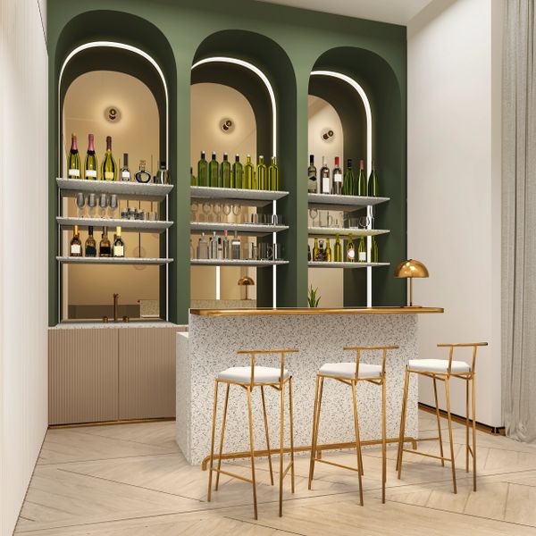 Elegant home bar with green arches, gold accents, and stylish high chairs.