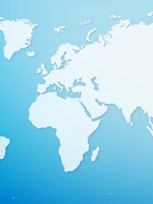 Businessman on phone with world map and international flags background.