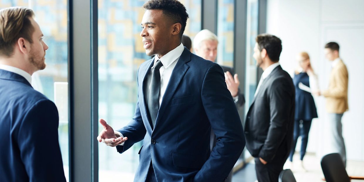 Business professionals engaging in conversation in a modern office.