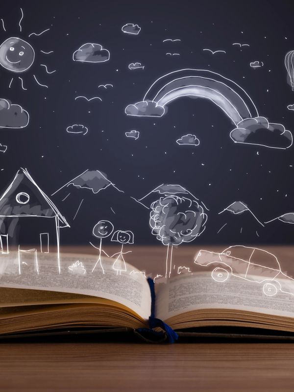 An open book with whimsical white sketches of a house, mountains, and sun above it.